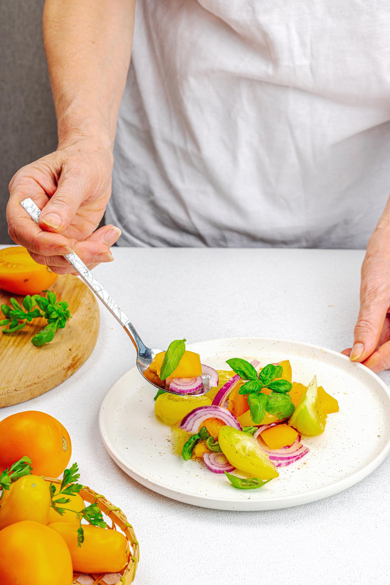 Chef plating a composed dish in a bright kitchen